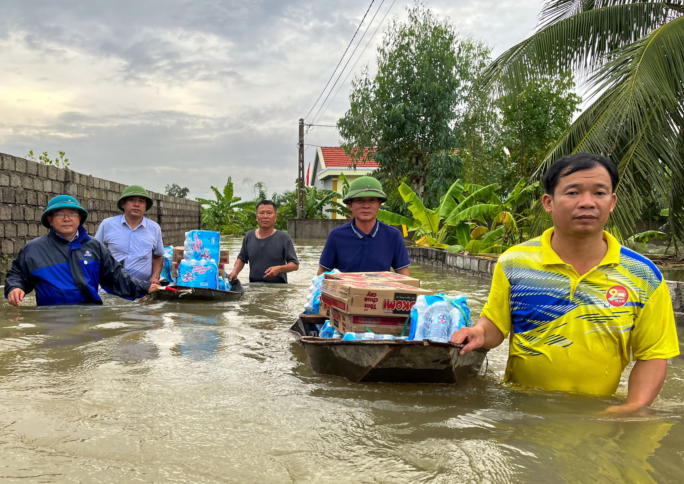 Lội nước đẩy thuyền tiếp tế các hộ dân bị cô lập trong lũ ở Quỳnh Lưu