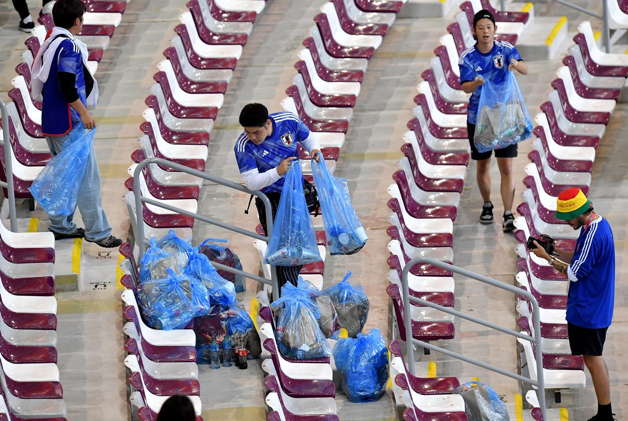 Khá đông CĐV xứ sở Phù Tang nán lại để dọn dẹp rác trên các khán đài sân Khalifa 