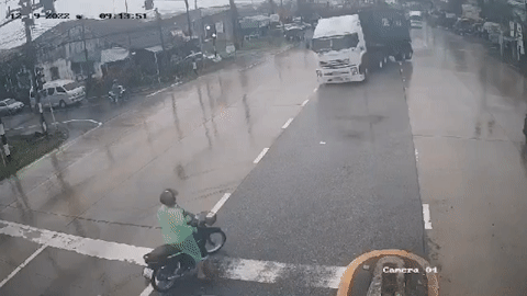 Xe máy dừng đèn đỏ kịp thoát nạn trước đầu xe container đang lao ngược chiều đến