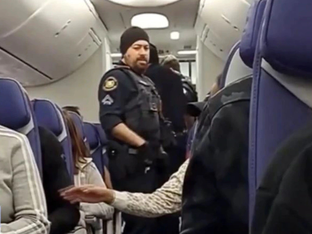 Nữ hành khách đòi mở cửa máy bay, cắn hành khách khác bị áp giải khỏi máy bay