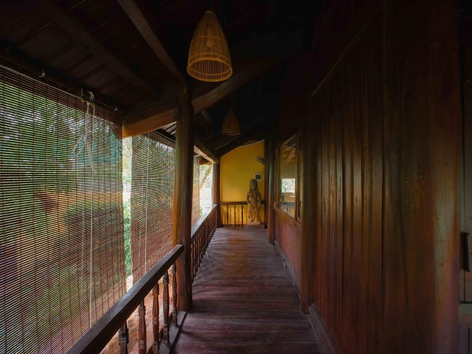 The 150m2 ancient house on stilts in Hoa Binh has a large verandah, a monolithic stone bath