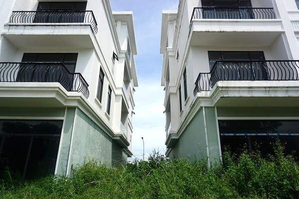 A series of shophouses in the center of Da Nang are covered with grass and degraded