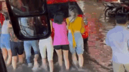 Nhóm khách nữ xắn quần xuống đẩy ô tô chết máy giữa đường ngập