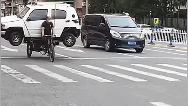 Kinh ngạc người đàn ông dùng xe đạp chở ô tô trên phố