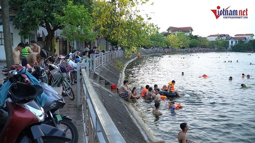 Nắng nóng kéo dài, người Hà Nội rủ nhau ra hồ tắm giải nhiệt đông như bãi biển