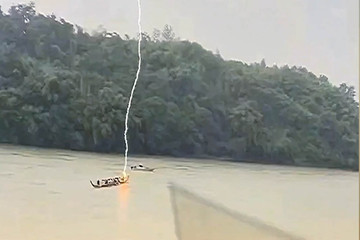 Khoảnh khắc sét đánh trúng người đàn ông đang chèo thuyền trên sông