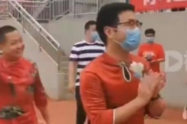 Male teacher wearing cheongsam cheers students on for college entrance exams