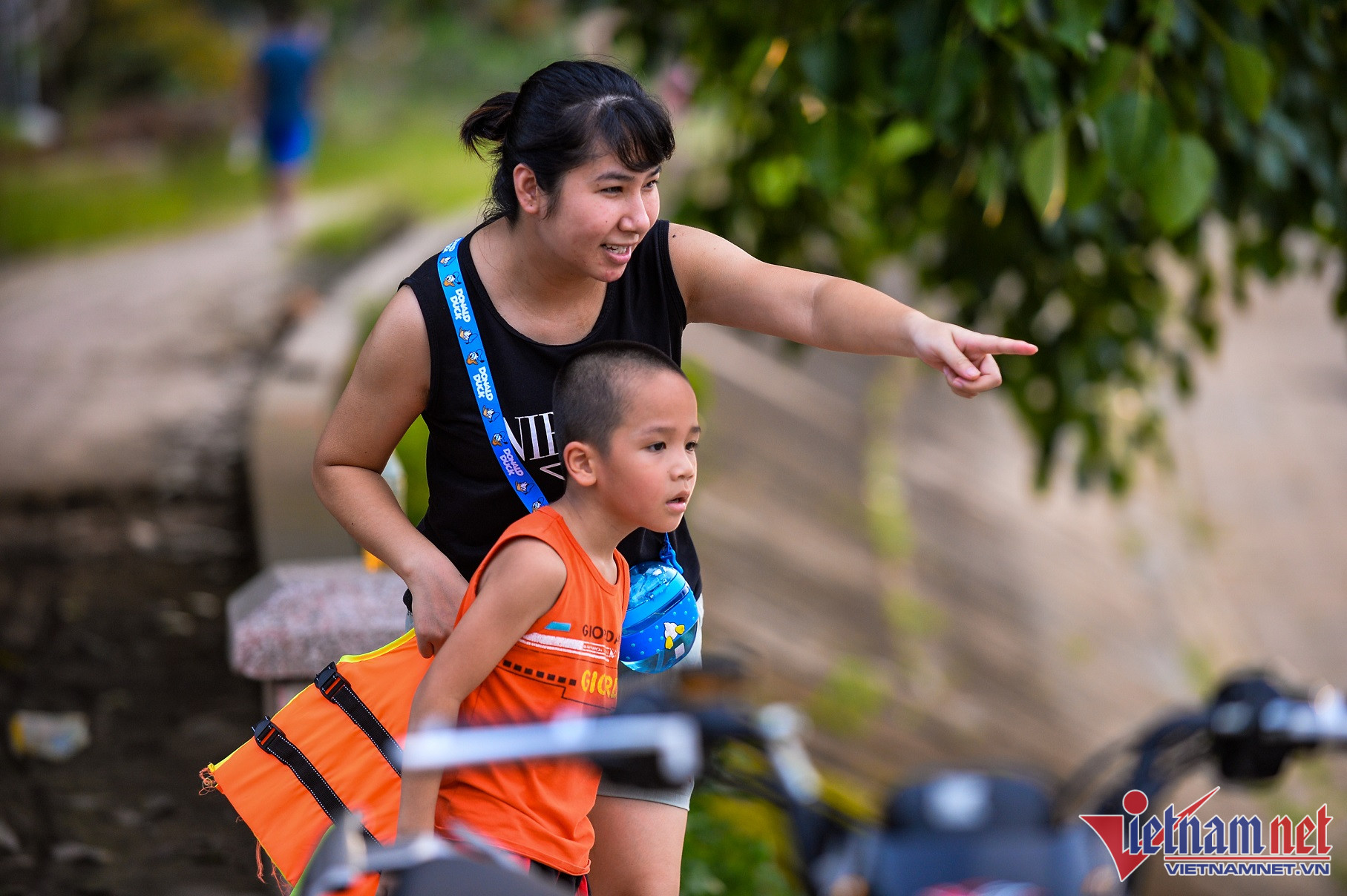 Nhà gần hồ, chị Lan Anh thỉnh thoảng đưa con ra tắm mát cùng các bạn hàng xóm. Nhìn thấy nhóm bạn, cậu bé Huy nhanh chóng mặc áo phao rồi nhảy xuống vui chơi cùng các bạn.