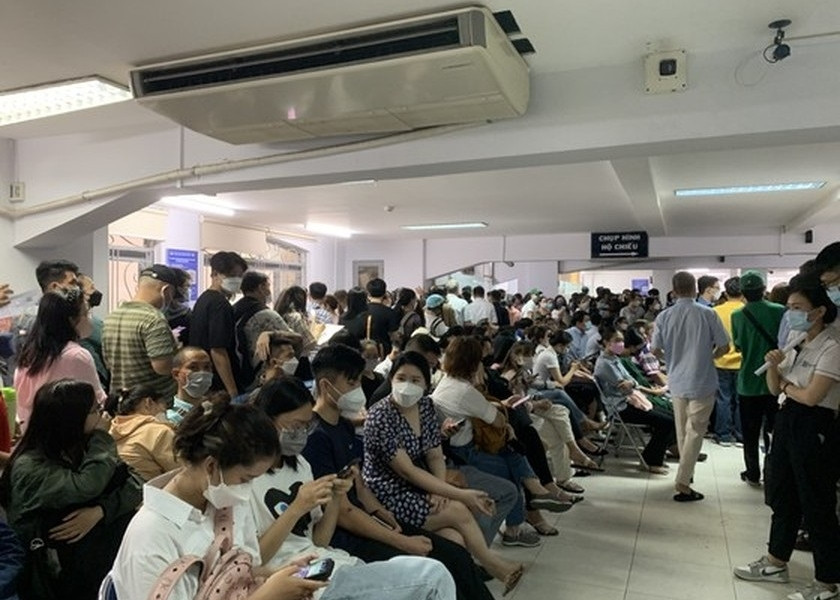 People in HCMC wait in long queues at passport office on July 1