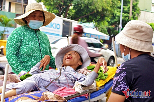 Mẹ đưa con bại não đi bán vé số, tối ngả lưng trên hai miếng gạch