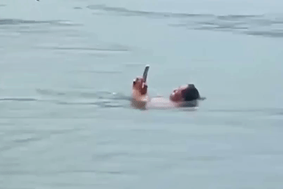Du khách bơi giữa hồ nước sâu vẫn tay lướt điện thoại, mắt dán vào màn hình