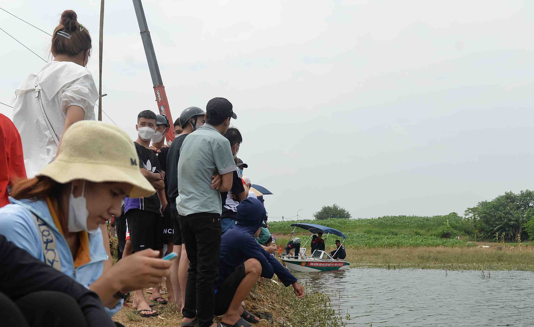 Người dân đứng kín bờ sông theo dõi tìm cô gái Hà Nội mất tích