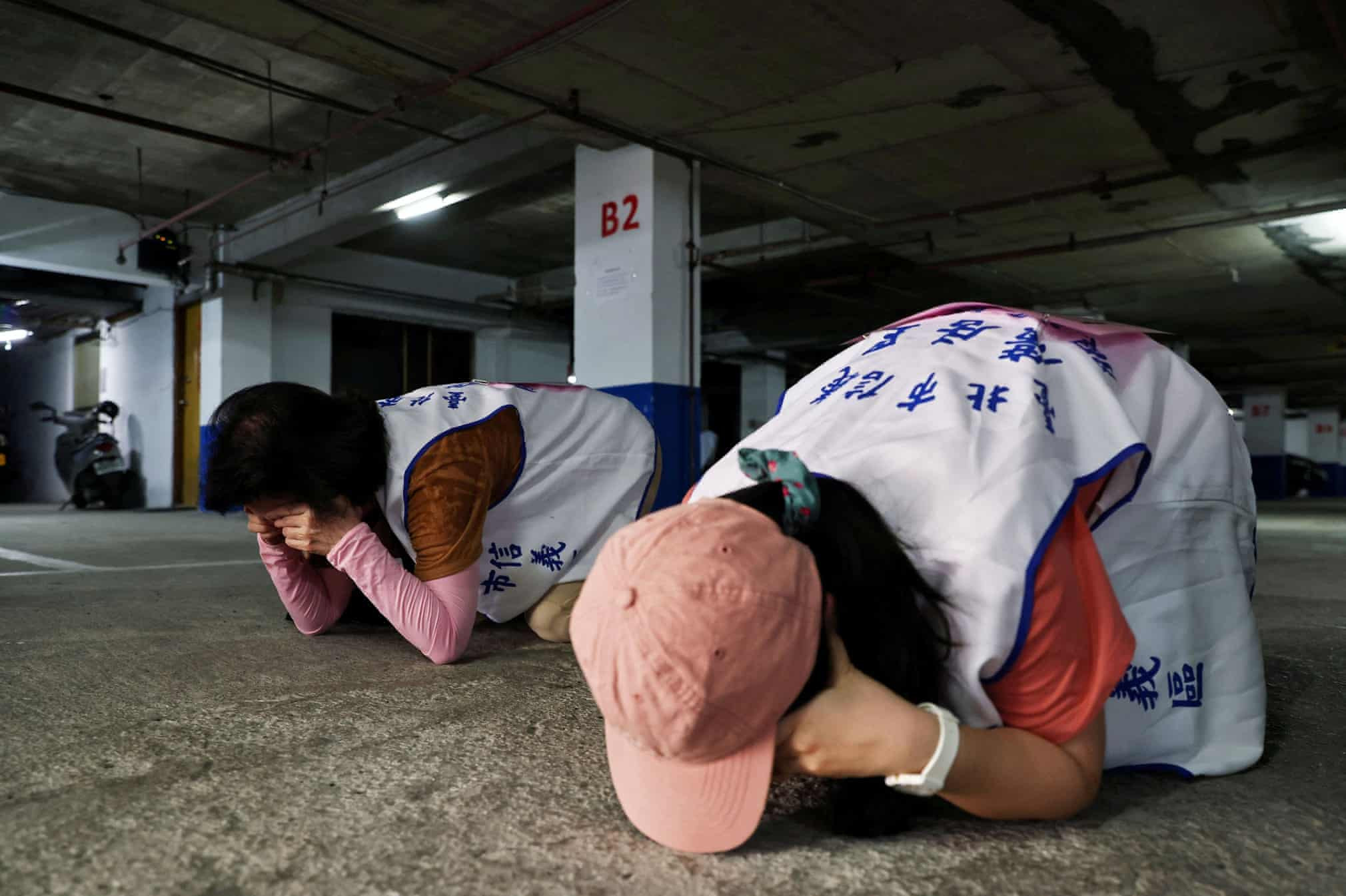 Người dân Đài Loan tập cách che mắt và tai trong khi há miệng để giảm tác động của sóng âm gây ra từ những vụ nổ. Ảnh: Reuters