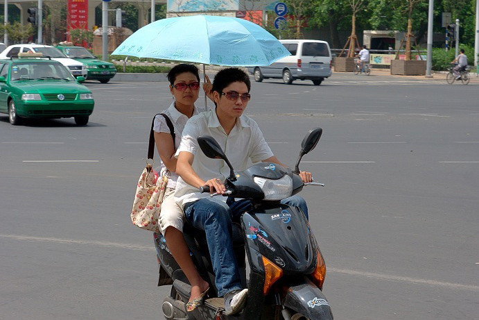 Cầm ô dù lái xe máy, thói quen nguy hiểm