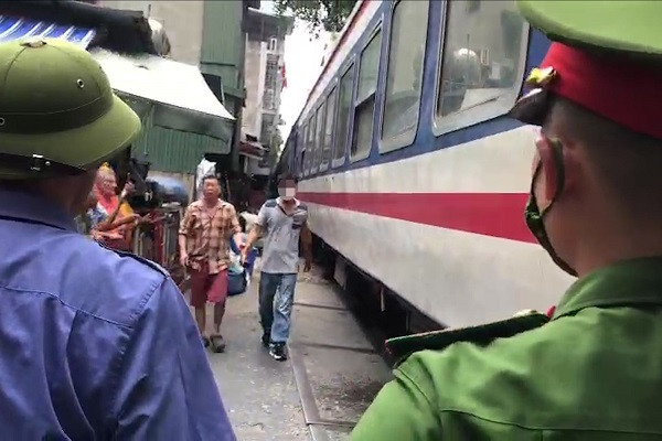 Cố lách vào chụp ảnh, người đàn ông bị tàu hất văng vào tường