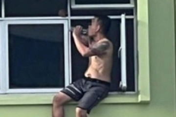 Người đàn ông Singapore ngồi uống rượu ở bệ cửa sổ tầng 11 để trốn nợ