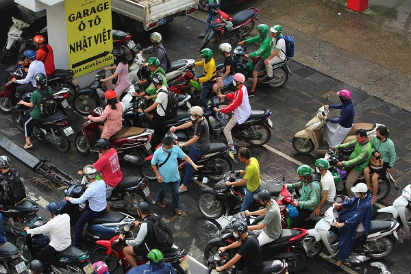 Ô tô xếp hàng dài, xe máy tranh vỉa hè với người đi bộ trên đường phố Hà Nội