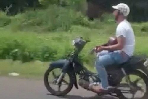 Thanh niên tay đánh đàn, chân lái xe máy lao vun vút trên quốc lộ