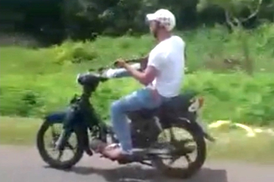 Thanh niên tay đánh đàn, chân lái xe máy lao vun vút trên quốc lộ - 2