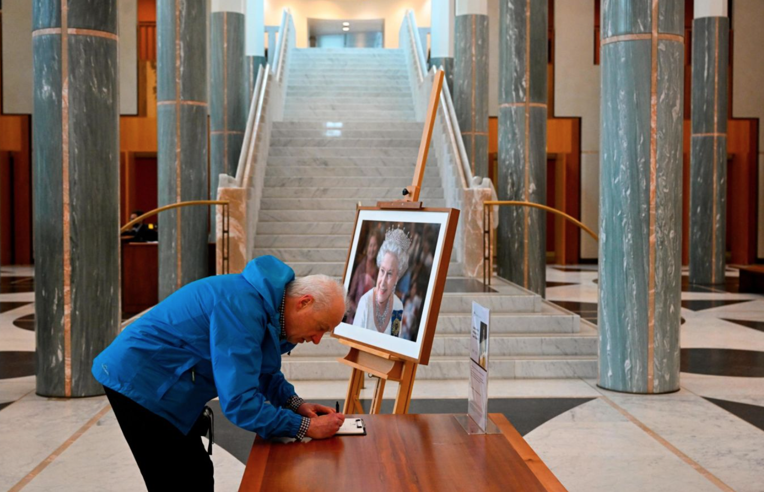 Một du khách ký vào sổ tang tưởng niệm Nữ hoàng bên trong Tòa nhà Quốc hội ở Canberra, Australia.
