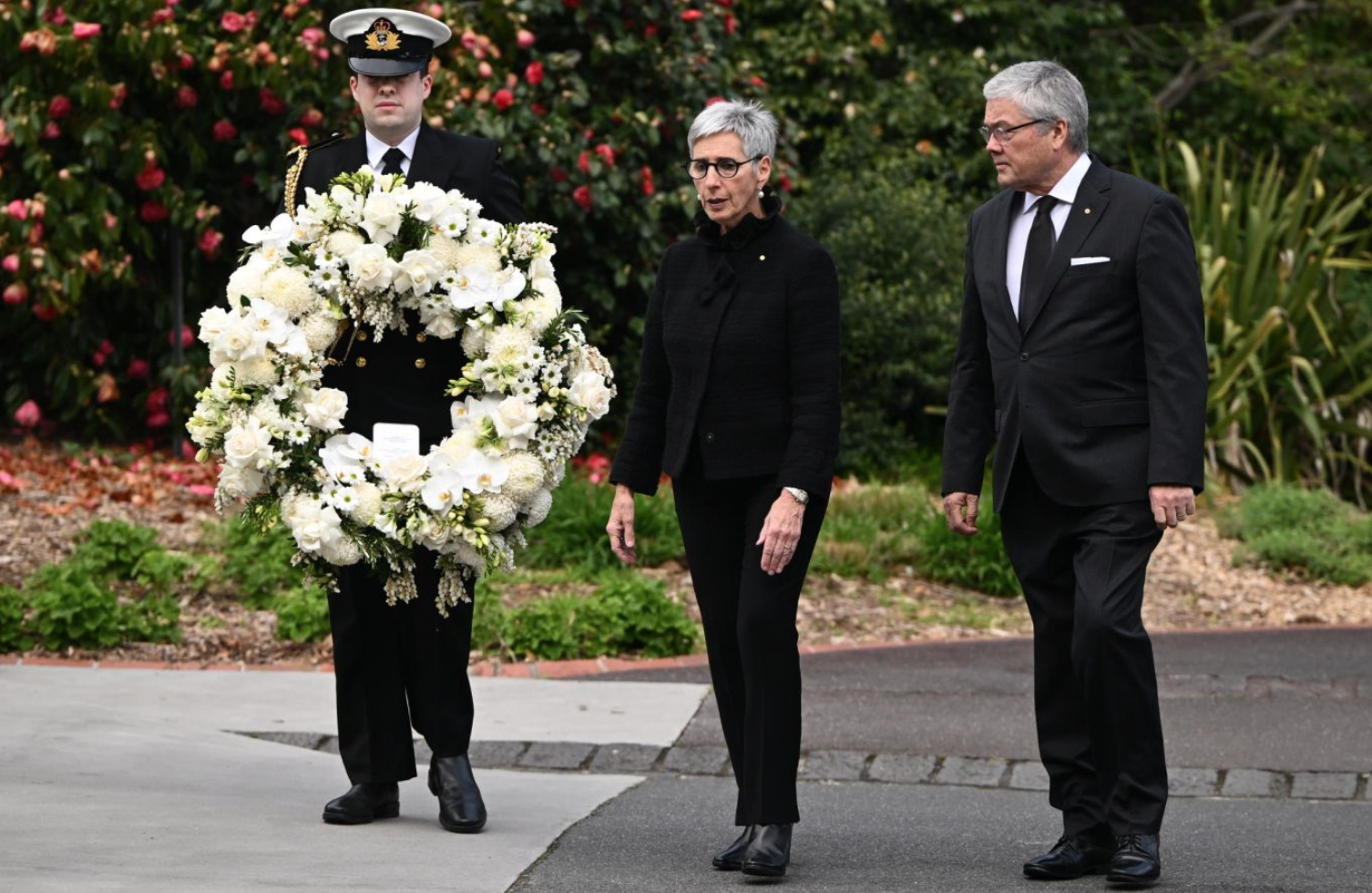 Thống đốc bang Victoria, Australia - bà Linda Dessau và chồng Anthony Howard đến đặt vòng hoa trước cổng Tòa nhà Chính phủ ở Melbourne.