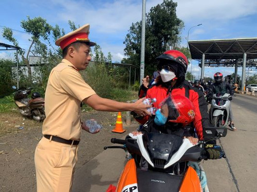 Cảnh sát giao thông Đắk Nông phát nước uống, bánh mì cho người dân trở lại sau Tết