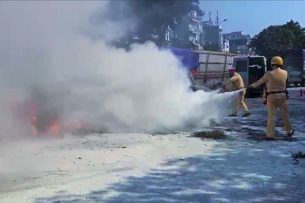 Xe máy bùng cháy giữa bãi đỗ ô tô ở Hà Nội, CSGT dùng bình cứu hỏa ứng cứu