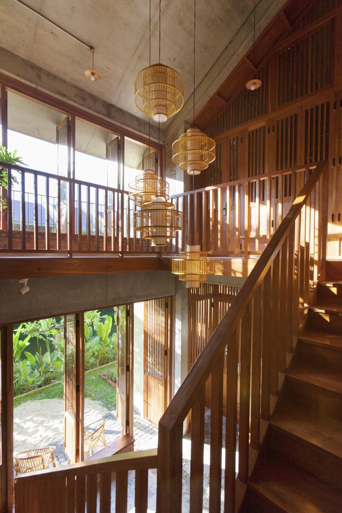 Sàn tầng 2 được khoét đi để tạo thành thông tầng kết hợp cầu thang gỗ, điều này tạo nên sự kết - chuyển giữa hai tầng.