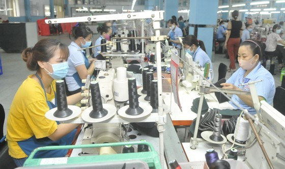 Making sports shoes for export at Freetrend Industrial Co. Ltd. (an FDI business in HCMC) (Photo: SGGP) ảnh 1