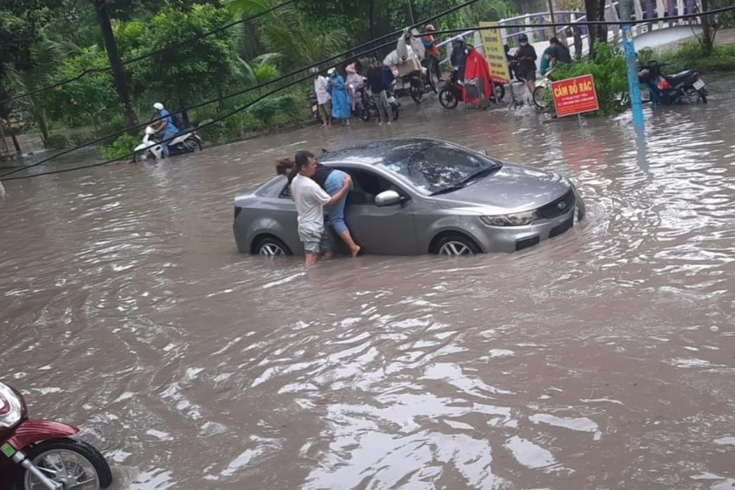 Mưa lớn kéo dài, ô tô 'bơi' trên đường ở Bình Dương