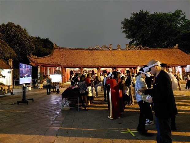 Tourists experience the night tour at Van Mieu - Quoc Tu Giam. (Photo: VNA) ảnh 1