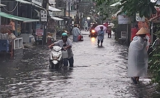 Local people walk through water while their vehicle is half-sumberged ảnh 2