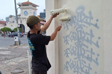 Thanh niên bị buộc sơn lại tường trước chợ Bến Thành sau khi vẽ bậy