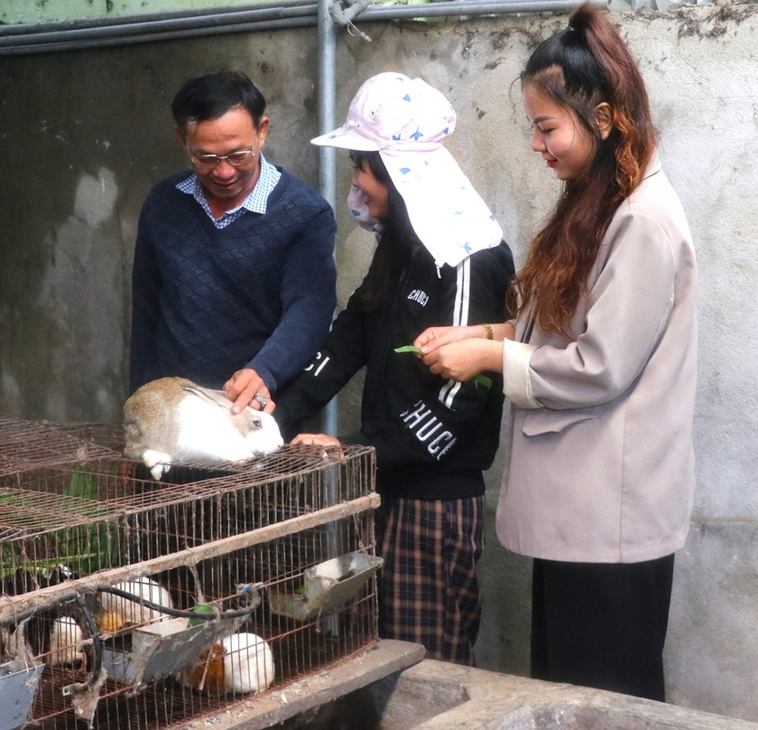 Cán bộ Hội Nông dân phường An Bình (thị xã An Khê) trao đổi kỹ thuật chăm sóc thỏ với chị Nguyễn Thị Thoa (đứng giữa, ở tổ 7). Ảnh: Ngọc Minh
