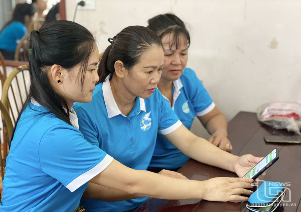 Phụ nữ phường Phố Cò tìm hiểu các ứng dụng số trên điện thoại.