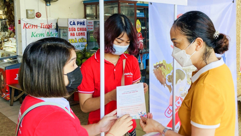 Nhân viên Viettel Quảng Ninh hướng dẫn tiểu thương Chợ Hạ Long 1 (TP Hạ Long) sử dụng ứng dụng Viettel Money để thanh toán trực tuyến.