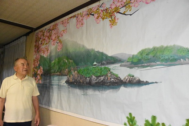 Ông Tatsuo Horiuchi bên cạnh một bức tranh ông vẽ hoàn toàn bằng Excel (Ảnh: SoraNews).