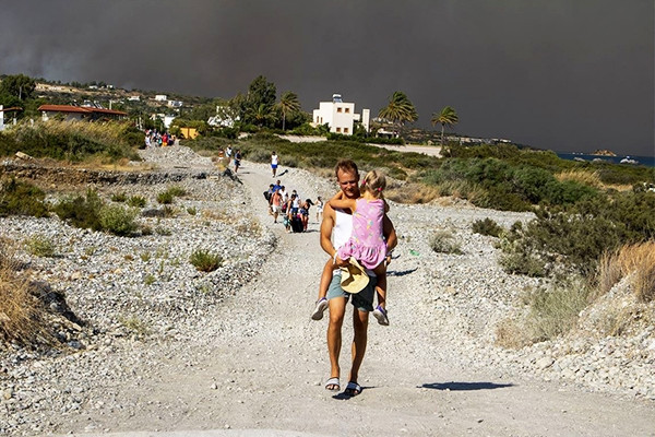 Khách du lịch mặc đồ bơi tháo chạy khỏi đám cháy trên đảo