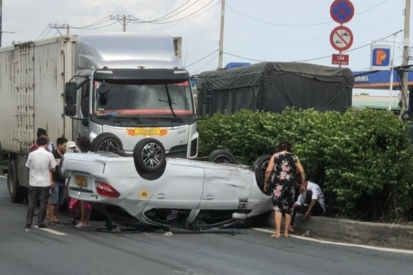 Ô tô chở 5 người lật ngửa trước đầu xe tải đang chạy trên quốc lộ 1