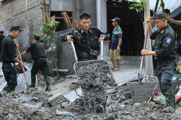 Chiến sĩ Cảnh sát cơ động giúp dân dọn bùn từ vụ vỡ cống tràn xả thải ở Lào Cai