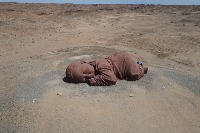 Ý nghĩa của bức tượng em bé khổng lồ, nằm đơn côi giữa sa mạc Trung Quốc