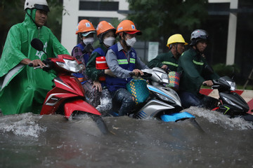 Mưa lớn ở TP.HCM, người dân đánh vật với làn nước ngập