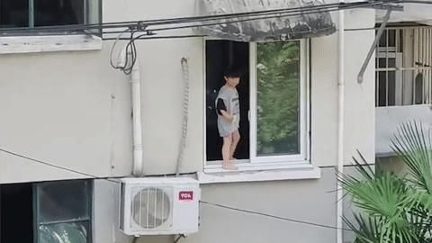 Hãi hùng cảnh cậu bé đứng bấp bênh bên mép cửa sổ chung cư