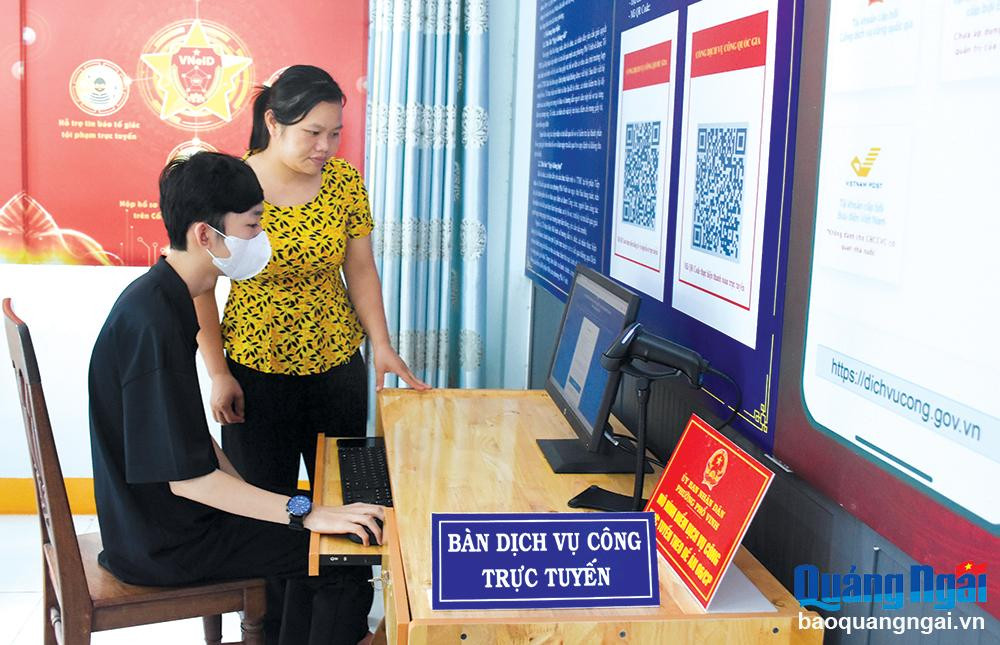 Công chức phường Phổ Vinh (TX.Đức Phổ) hướng dẫn người dân thực hiện dịch vụ công trực tuyến. Ảnh: PV