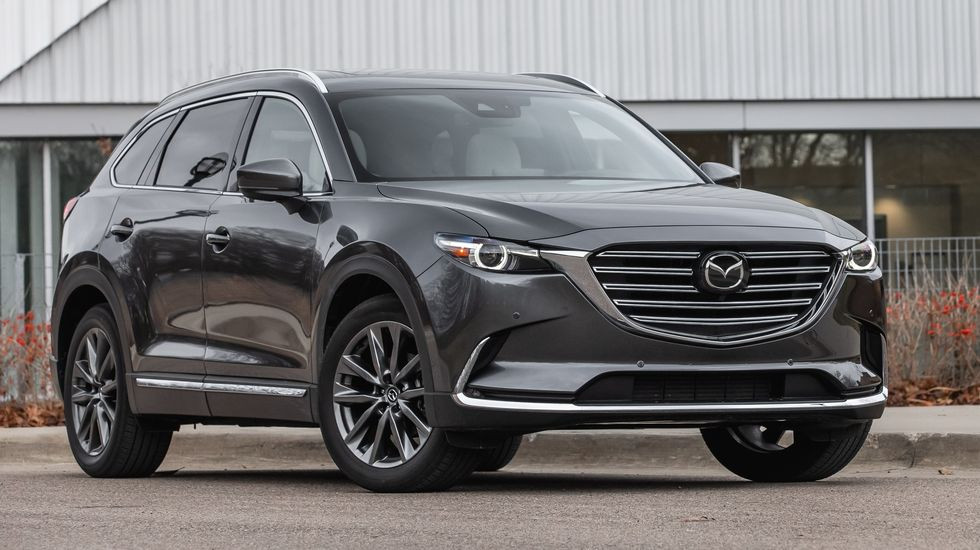 2023 charcoal gray mazda cx 9 suv parked near the sidewalk