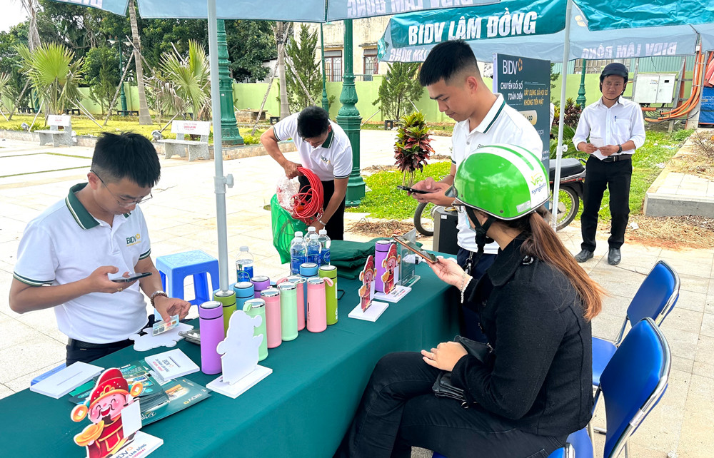 Nhân viên ngân hàng BIDV hướng dẫn cho người dân tham gia các tiện ích thanh toán không dùng tiền mặt