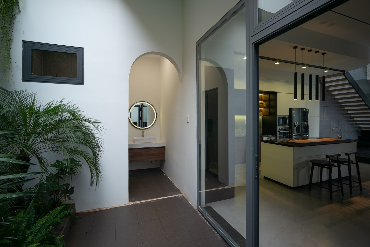 Khu vệ sinh ở tầng 1 được đặt cuối nhà để tách biệt với không gian sinh hoạt, cạnh lối vào được trồng cây xanh.