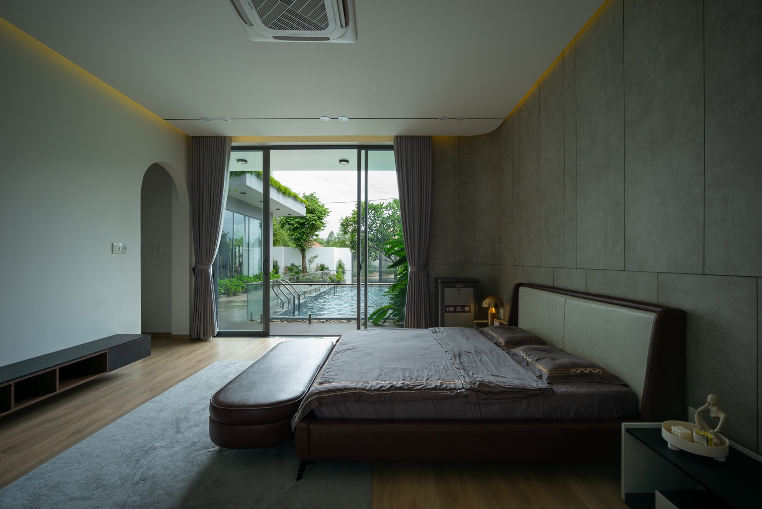 Phòng ngủ master nằm sát khu hồ bơi; xung quanh hai mặt phòng đều có các khoảng thở phối hợp với cây xanh.