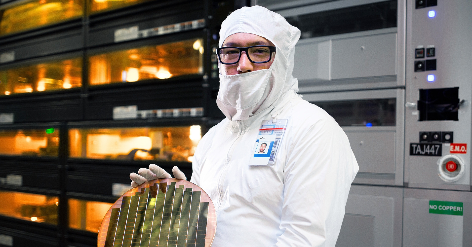 Engineer holding a silicon wafer inside an Intel semiconductor fabrication facility