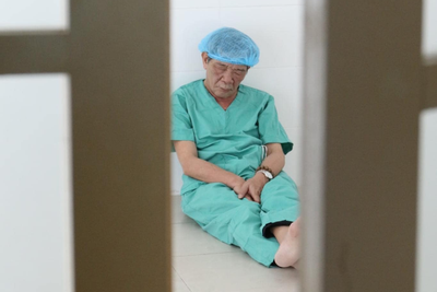 Bác sĩ 62 tuổi ngồi bệt trên sàn nhà, chợp mắt sau ca mổ miễn phí